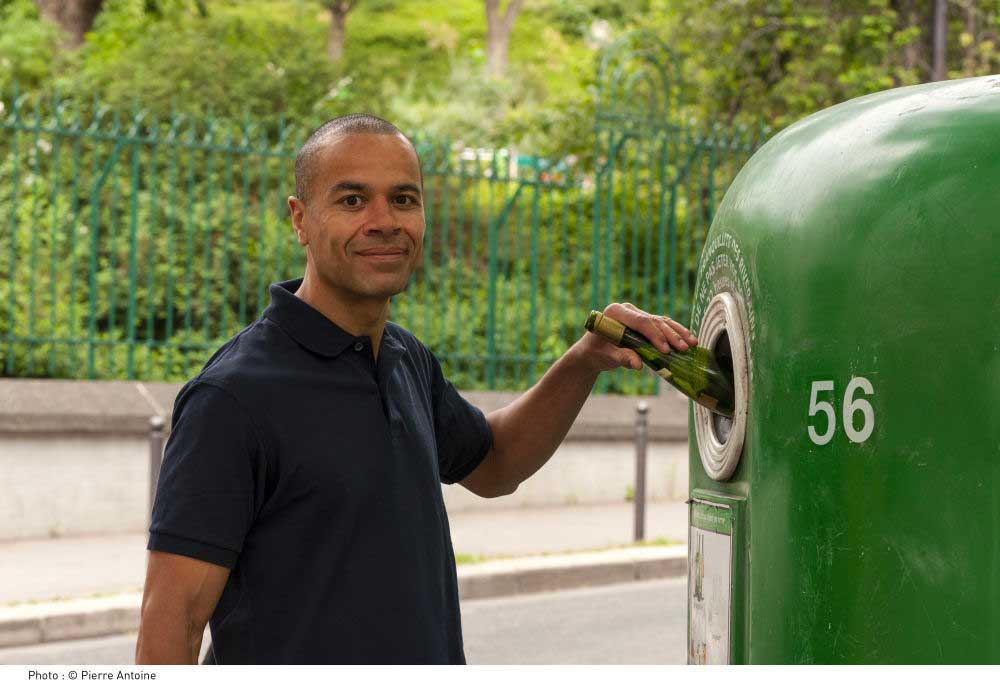 Geste de tri d'une bouteille en verre