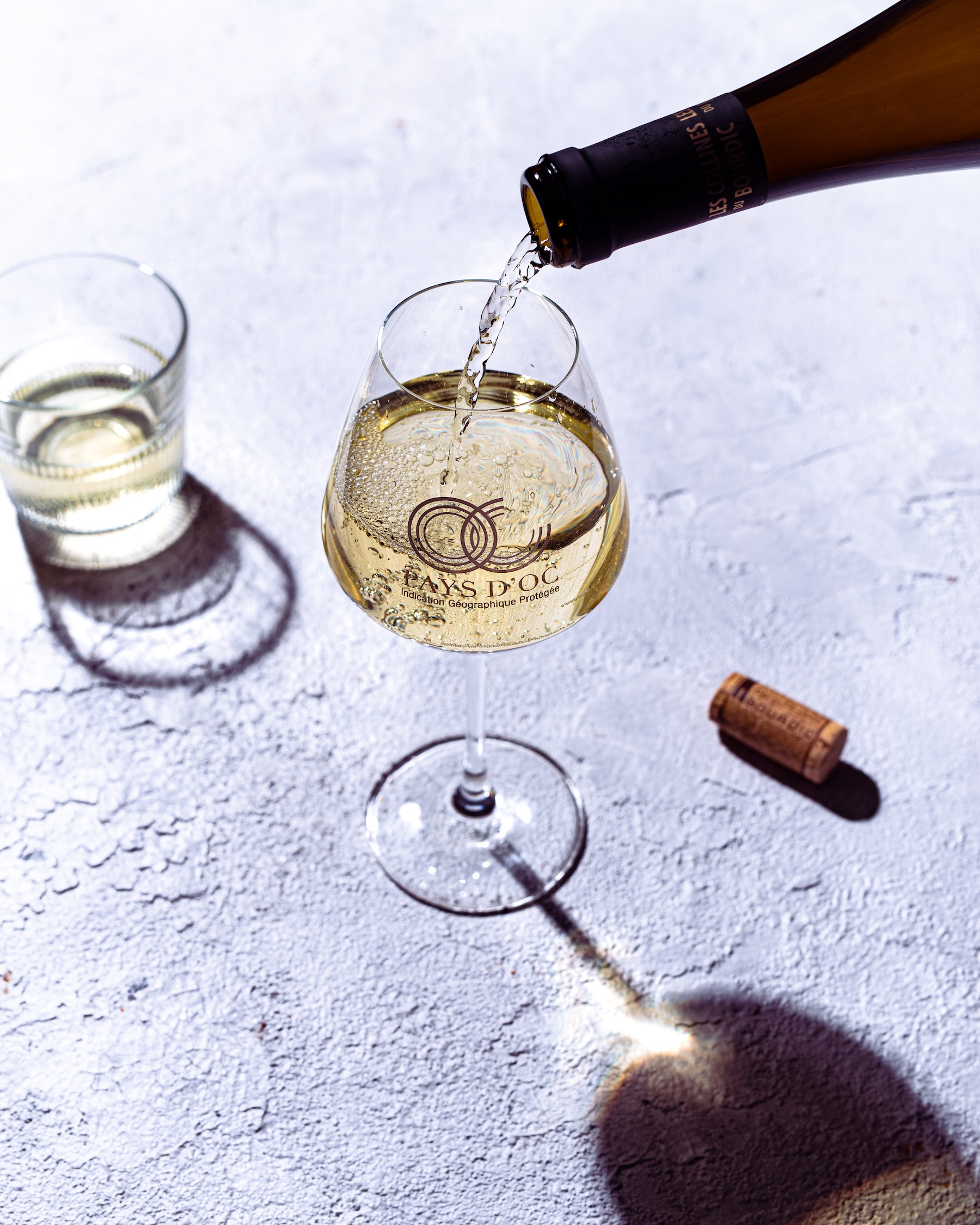 Weißwein wird in ein Pays d'Oc IGP Glas gegossen.